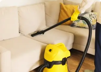Upholstery steam cleaning of a beige sofa using a yellow vacuum extractor